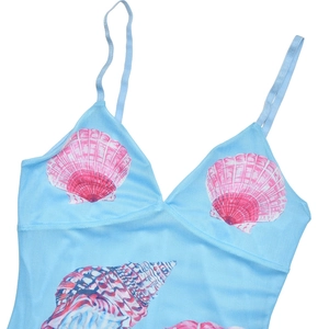 Close-up of light blue sundress featuring pink and purple seashell prints and slim straps