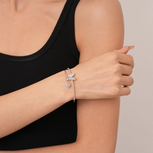 Detail of silver butterfly and clover bangle with sparkling rhinestones on model's wrist