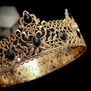 Detailed close-up of a vintage baroque gold crown featuring black oval gemstones