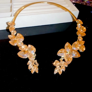 Detail of gold choker necklace with champagne amber leaf-shaped crystals in a luxe design