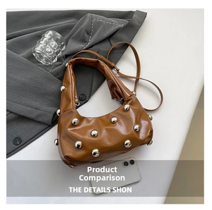 Detailed view of caramel patent leather hobo bag with large silver spherical rivets