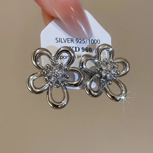 Macro detail of 925 silver flower stud earrings with sparkling zircon crystals