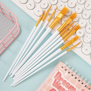 Detailed view of 10 nylon paintbrushes with white handles and golden ferrules in a creative setup
