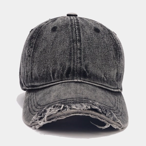 Detail shot of distressed brim on charcoal grey washed denim retro baseball cap