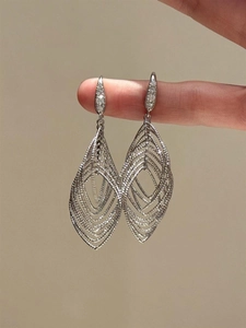 Detail showing silver layered hollow oval leaf earrings with zircon stone accents on fingers