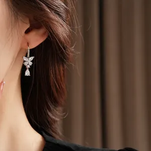 Elegant silver butterfly drop earrings with cubic zirconia stones worn by a model