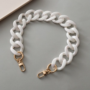 Macro shot of chunky pearlescent white resin chain strap with gold lobster clasps