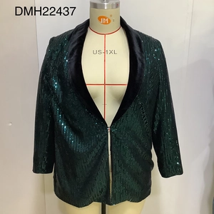 Detailed view of green sequins in wavy patterns and black velvet lapels on the blazer