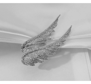 Detailed close-up of elegant silver angel wing brooch featuring micro-set white cubic zirconia