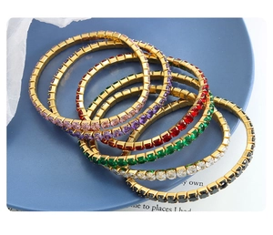 Detail of colorful zircon bracelets with 18K gold-plated settings on a blue tray