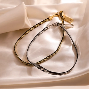 Adjustable 18K gold and silver plated zipper necklaces on white satin background