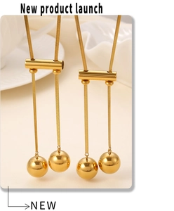 Detail of 18K gold plated snake chain necklace with hollow bead and tassel pendant