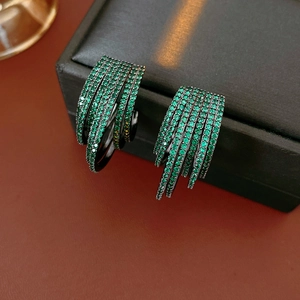Detail of green zircon multi-layer hoop earrings on black jewelry box and leather