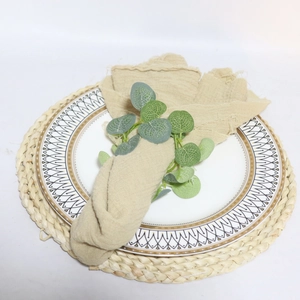 Easter eucalyptus leaf napkin ring with a frayed linen napkin on a white ceramic plate
