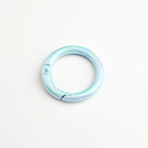 Close-up of a light blue iridescent round spring ring clasp for DIY jewelry making
