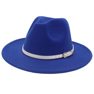 Detail of royal blue wool fedora hat featuring a white leather band and gold buckle