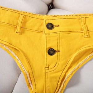 Gros plan sur un short en jean jaune montrant le bouton en métal et les détails de couture
