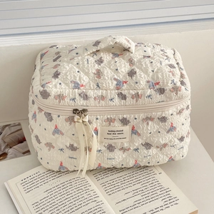 Close-up of quilted cosmetic bag featuring cute cartoon elephant and ribbon zipper detail