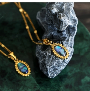 Macro shot of colorful abalone shell oval pendants on 18K gold plated stainless necklaces