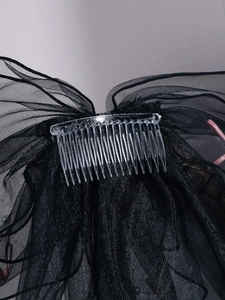 Close-up of black mesh bridal hair comb with layered tulle textures for party styling