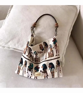 Close-up of Egyptian pharaoh embroidery and premium leather strap on a canvas tote