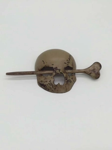 Macro shot of faux bone skull hair pin with weathered texture for Halloween styling