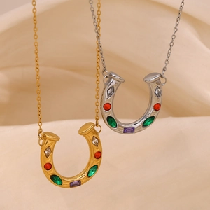 Close-up of gold and silver horseshoe pendants with colorful crystals on silk