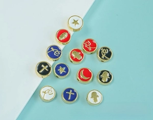 Detail of colorful enamel metal beads with gold cross and star patterns for DIY jewelry