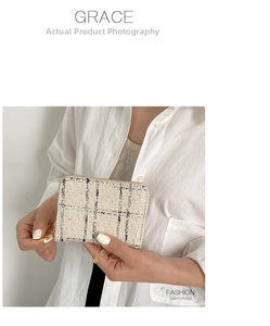 Close-up of a tweed small coin purse with gold zipper and stylish plaid weave texture