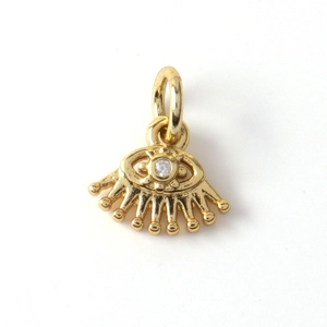 Macro detail of gold plated evil eye pendant with white zircon stone for DIY jewelry