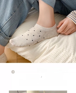 Dettaglio dei calzini invisibili in cotone beige con piccoli pois neri in stile giapponese