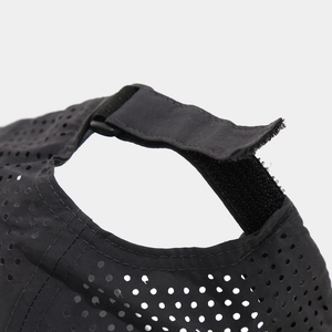 Detail of adjustable velcro strap and breathable laser-cut holes on baseball cap