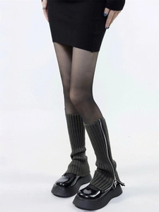 Detail of dark grey knit leg warmers featuring a side zipper over black platform boots