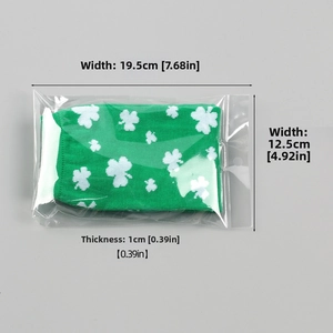Detail view of St. Patrick's Day green clover fingerless gloves in OPP packaging
