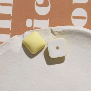 Detailed view of heart-shaped macaron resin DIY charms on a white ceramic plate
