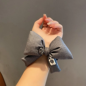 Elegant dark grey fabric bow hair tie with crystal centerpiece and camellia charm