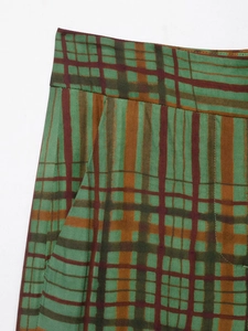 Détail du pantalon à carreaux vert et marron montrant la taille et les poches latérales