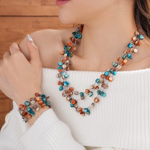Detailed view of bohemian multilayer shell bead necklace and bracelet on model