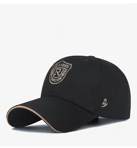 Detailed side view of black cotton baseball cap with gold crest embroidery and trim