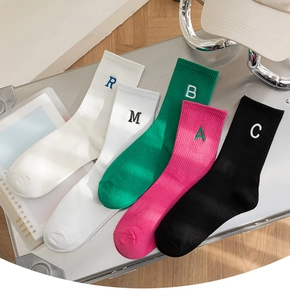 Detail showing five pairs of colorful cotton socks with vibrant ABC letter embroidery