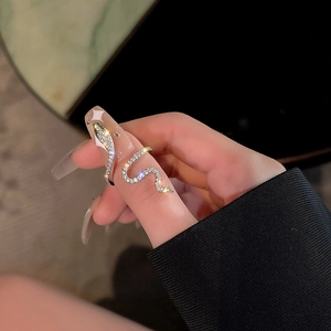 Micro-pave zircon serpent ring in silver metal worn on finger with sparkling stones