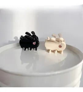 Detail of rabbit shaped mini acetate hair claws with pink rhinestone in black and white
