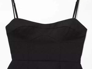 Détail de la robe noire à bretelles montrant le décolleté cœur et les coutures