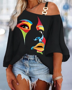 Detail eines schwarzen Cold-Shoulder-T-Shirts mit Goldring und buntem abstraktem Druck