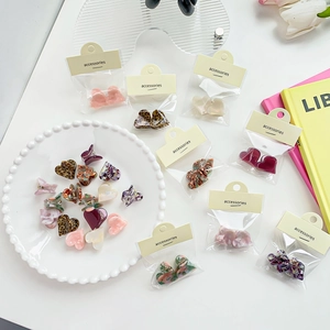 Mini pinces à cheveux en acétate en forme de cœur avec motifs léopard et floraux sur plateau