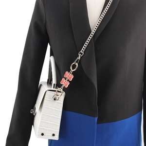 Silver metal chain strap with pink bow charms on a white crocodile pattern shoulder bag
