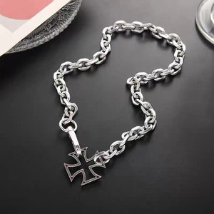Silver hollow iron cross necklace with red dots on a chunky cuban link chain
