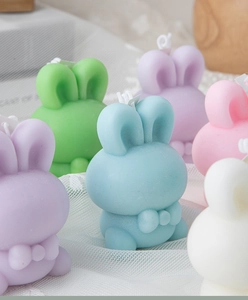 Group of colorful cute bunny scented candles in pastel blue, green, and pink shades