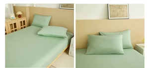 Detail view of sage green fitted sheet and pillowcase in a minimalist bedroom setting