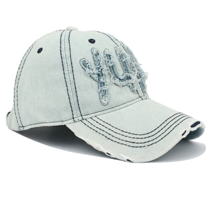 Détail d'une casquette en jean délavé avec écusson YUP effiloché et broderie vintage